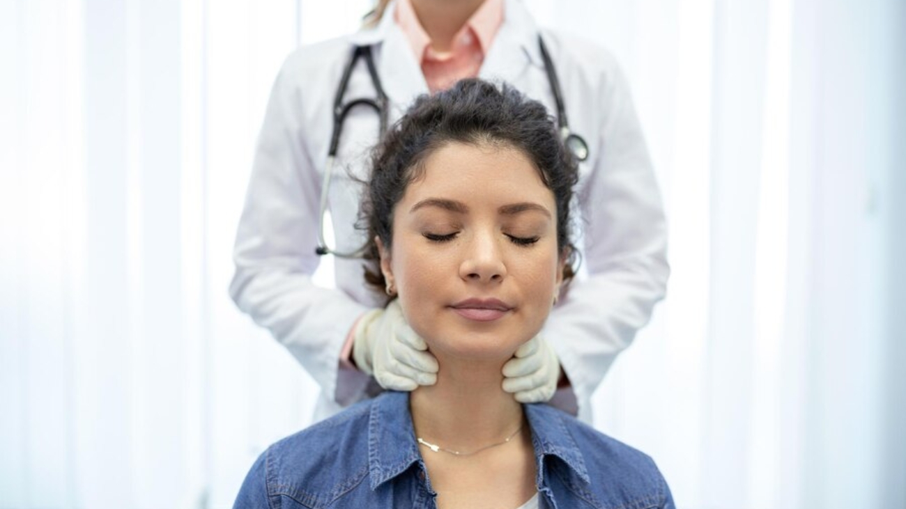 endocrinologo-examinando-garganta-mujer-joven-clinica-mujeres-prueba-glandula-tiroides-hormonas-endocrinologicas-tratamiento-inflamacion-dolor-garganta_1212-5497